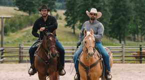 Rip and Jake advance toward the camera on horseback in Yellowstone