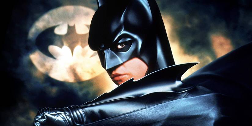 10 Best Batman Suit Designs In DC Movies & Shows, Ranked 4 Val Kilmer at Batman in front of the Bat Signal in Batman Forever