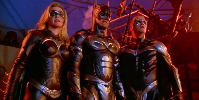 O elenco de Batman & Robin: George Clooney, Alicia Silverstone e Chris O'Donnell em um telhado.