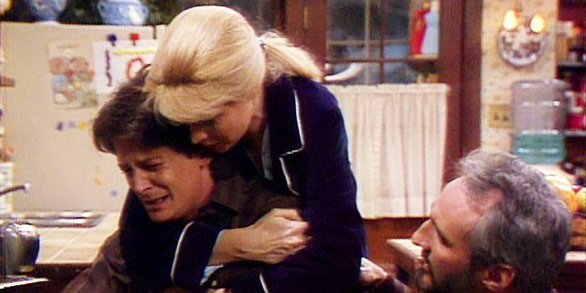 Alex breaks down in tears as his parents comfort him in Family Ties