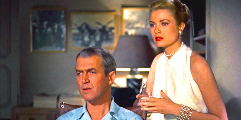 Jimmy Stewart und Grace Kelly in Rear Window stehen zusammen und starren mit angestrengtem Interesse auf etwas außerhalb des Bildschirms