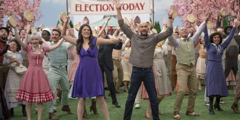 Josh e Melissa dançando com um coro ao fundo em Schmigadoon!