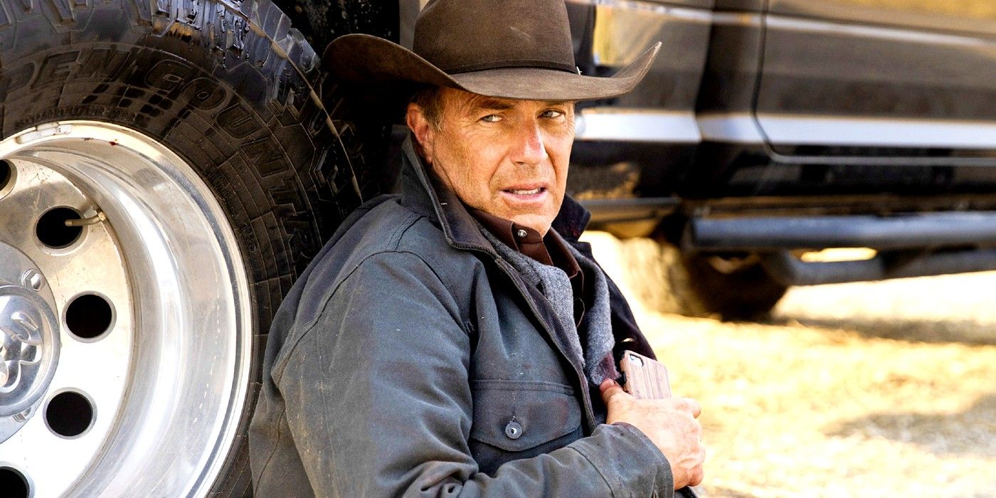 Kevin Costner as John Dutton holding onto his phone while lying against his truck in Yellowstone season 5