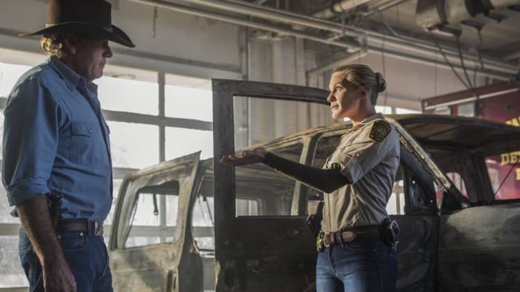 Walt and Vic talk in front of a burned out car in Longmire