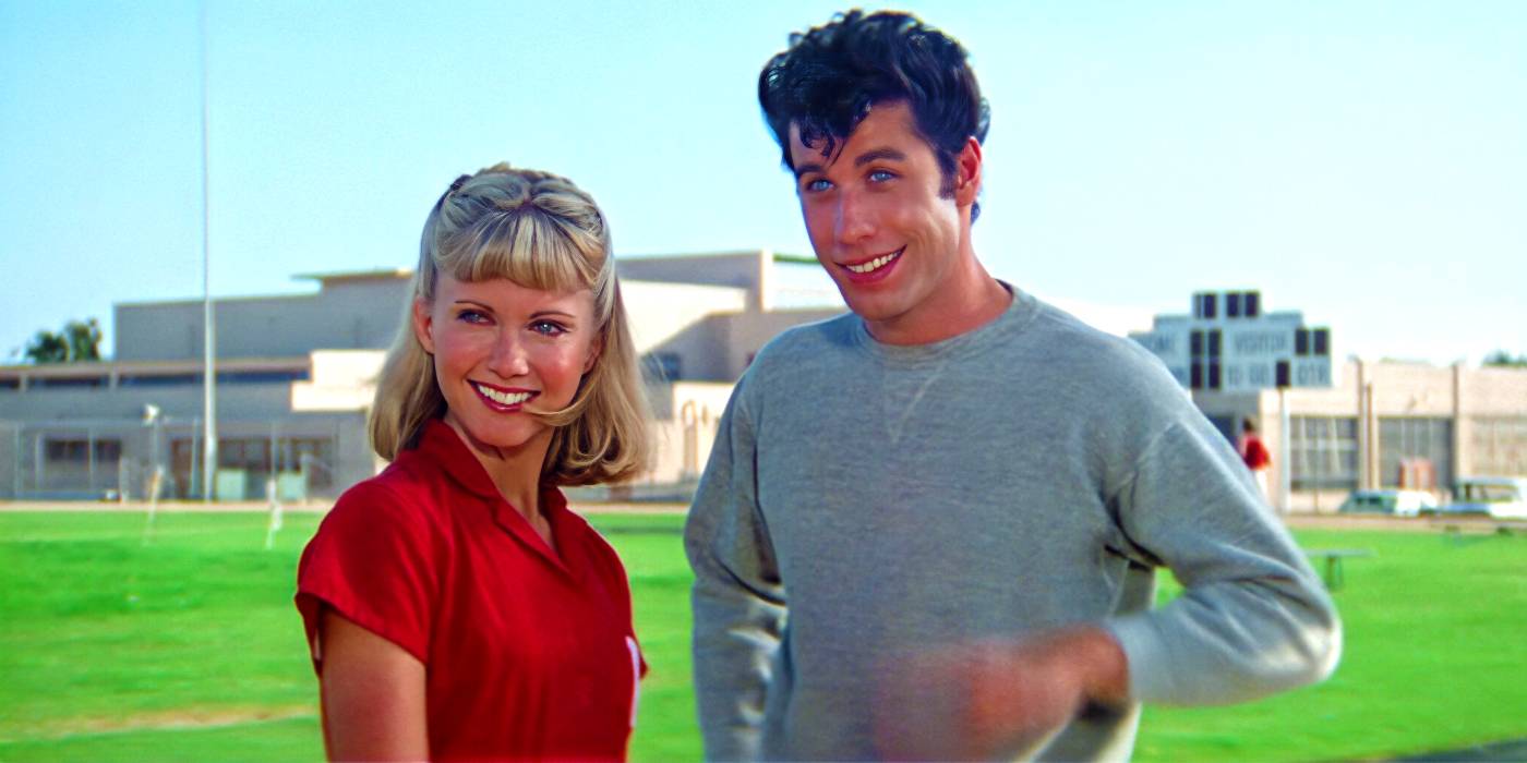 Olivia Newton-John and John Travolta smiling on the field in Grease