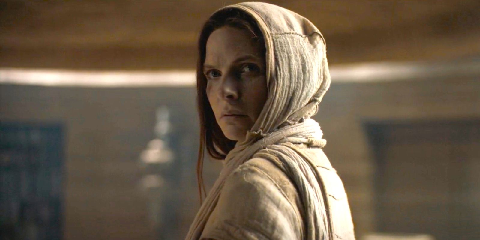 Rebecca Ferguson como Lady Jessica usando um capuz parecendo preocupada em Duna