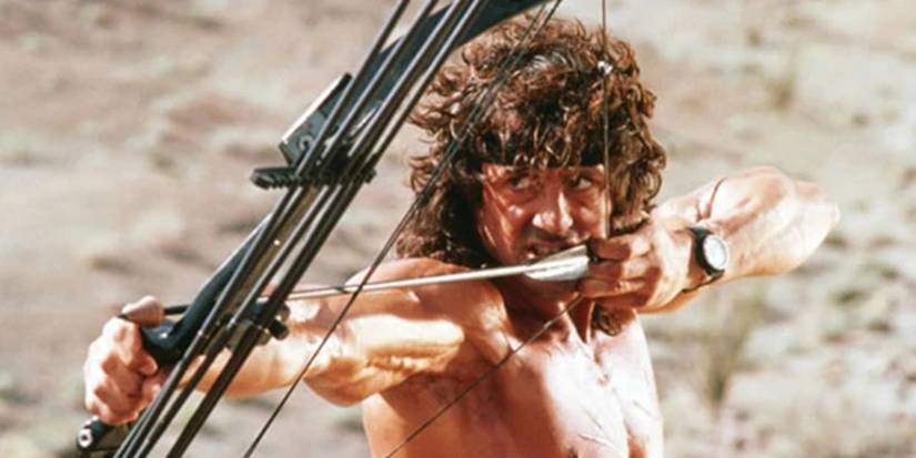Sylvester Stallone como John Rambo usando arco e flecha em Rambo 3