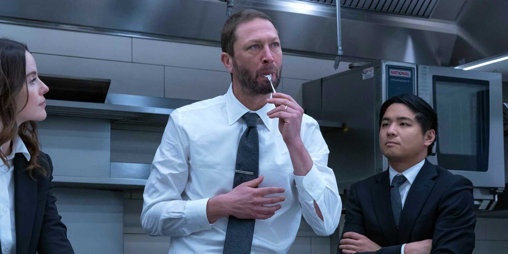 Richie tastes something in the kitchen with Garrett and Jessica in The Bear