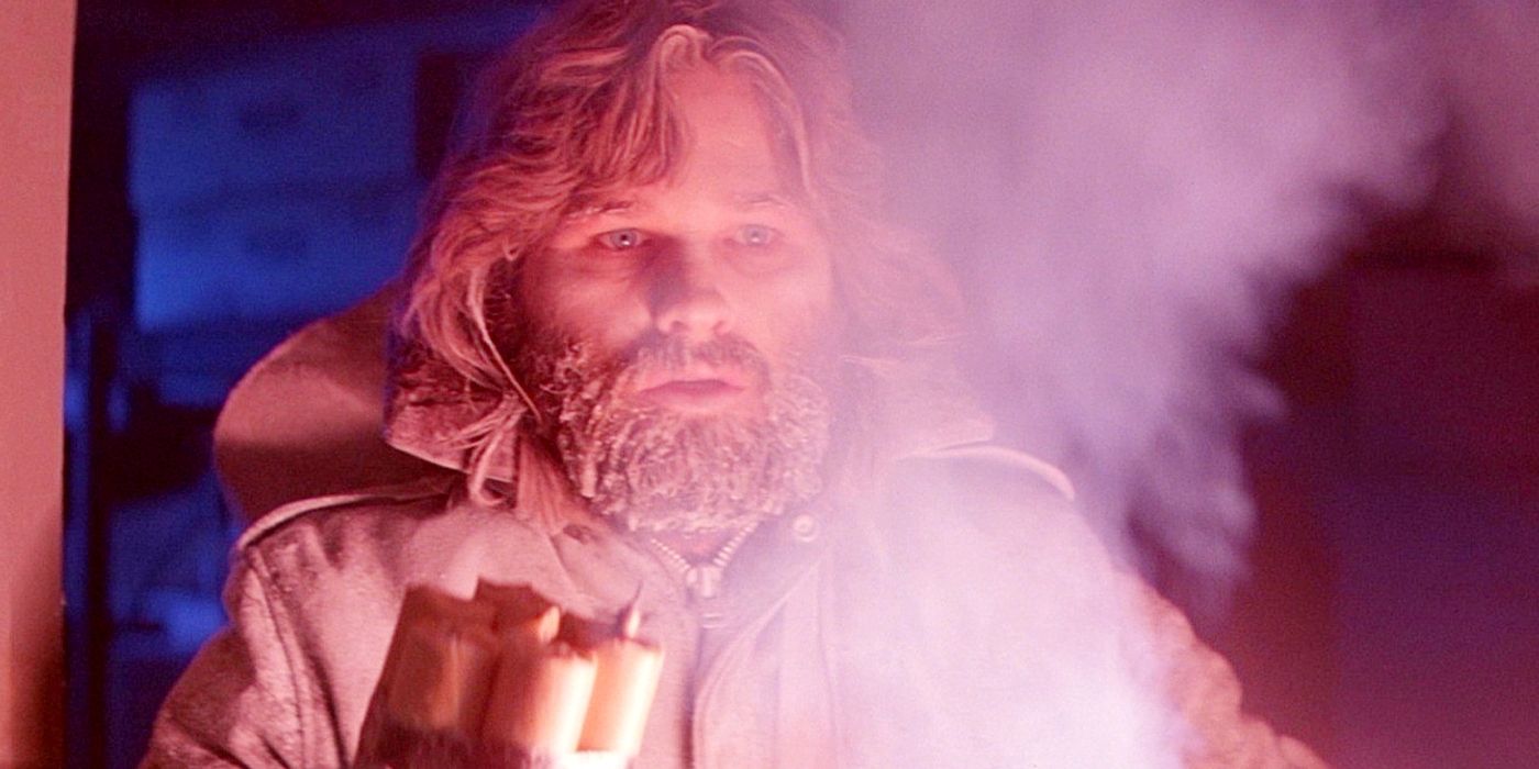 Kurt Russell as MacReady holding dynamite in The Thing.