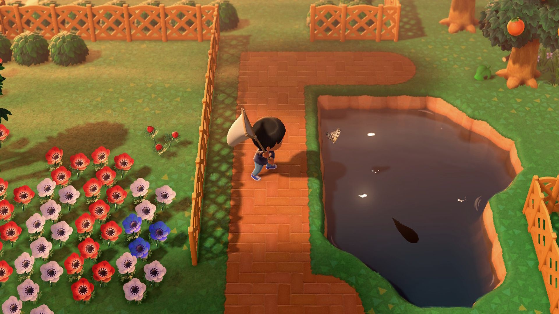 Animal Crossing New Horizons Player prepares to catch butterfly over the pond at sunset