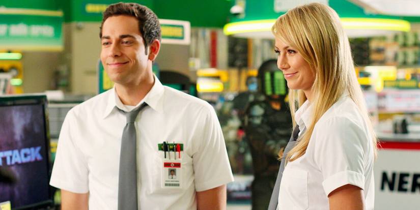 Zachary Levi as Chuck smiling sheepishly while standing next to his workmate