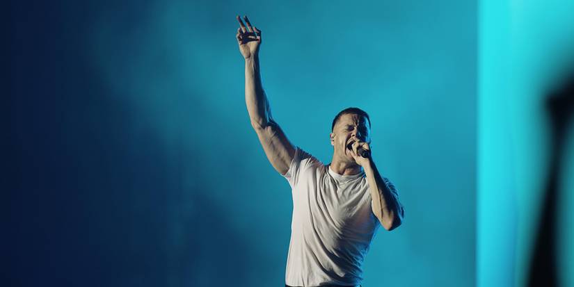 dan with arm up during natural at imagine dragons concert