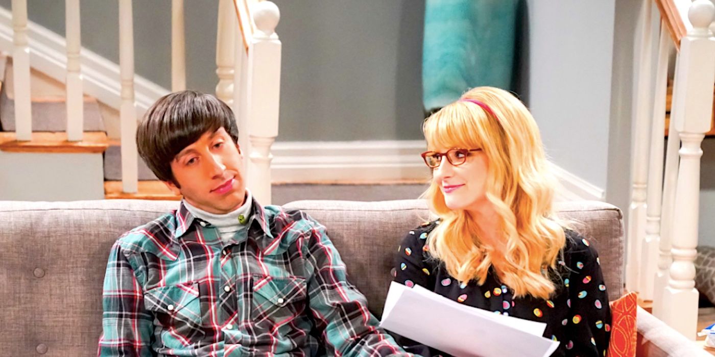 Howard and Bernadette sitting on their couch looking at paperwork in The Big Bang Theory