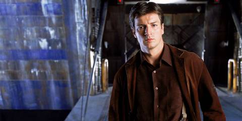 Nathan Fillion as Mal Reynolds standing by a loading dock in Firefly