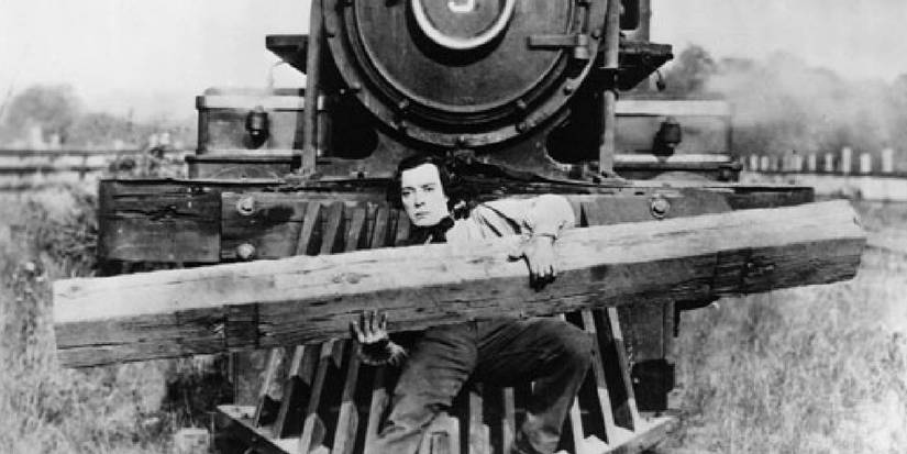 Buster Keaton em O General, segurando um tronco na frente de um trem.