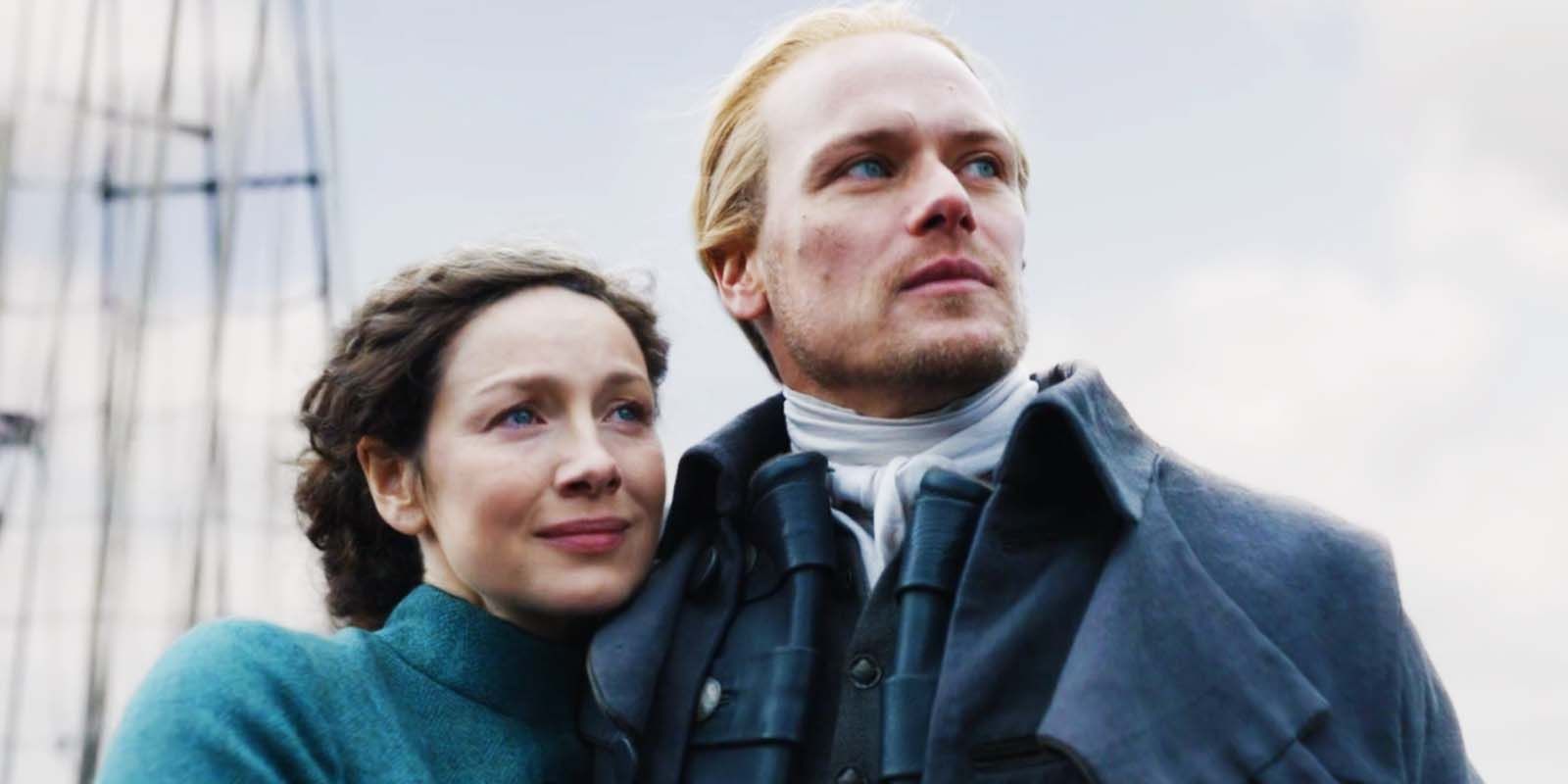 Caitríona Balfe as Claire Fraser and Sam Heughan as Jamie Fraser smiling and holding each other in Outlander season 7 midseason finale