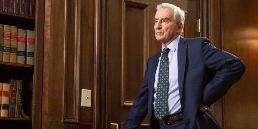 Jack McCoy (Sam Waterston) in Law & Order, standing by his bookshelf in his office and wearing a polka-dot tie