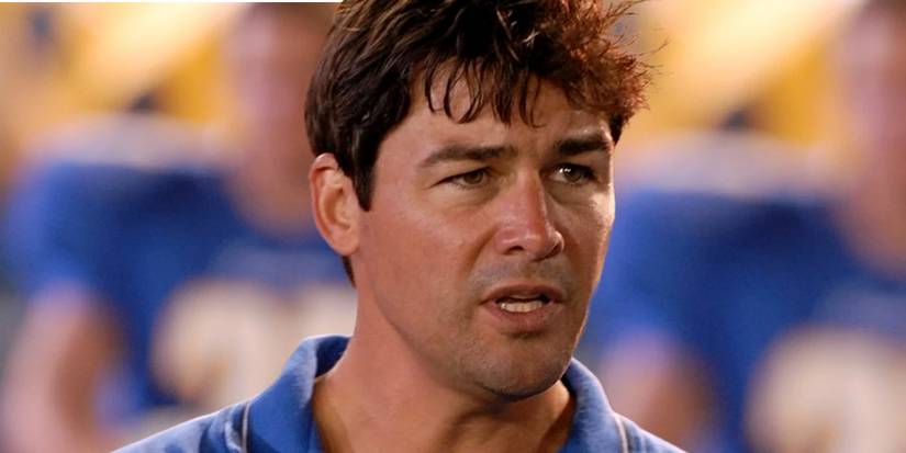 Kyle Chandler as Coach Taylor speaking among football players in Friday Night Lights