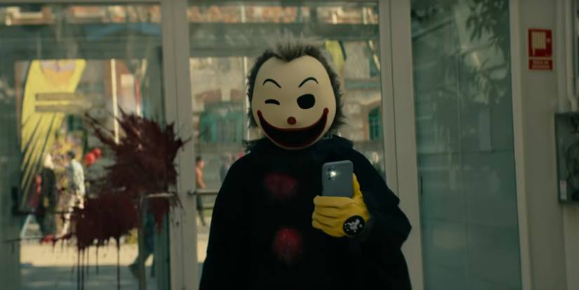 Mad Clown держит телефон со стримом, показывающим его последнее убийство.