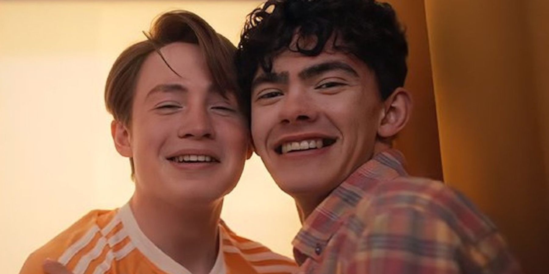 Nick and Charlie smile while taking a selfie in Heartstopper season 2