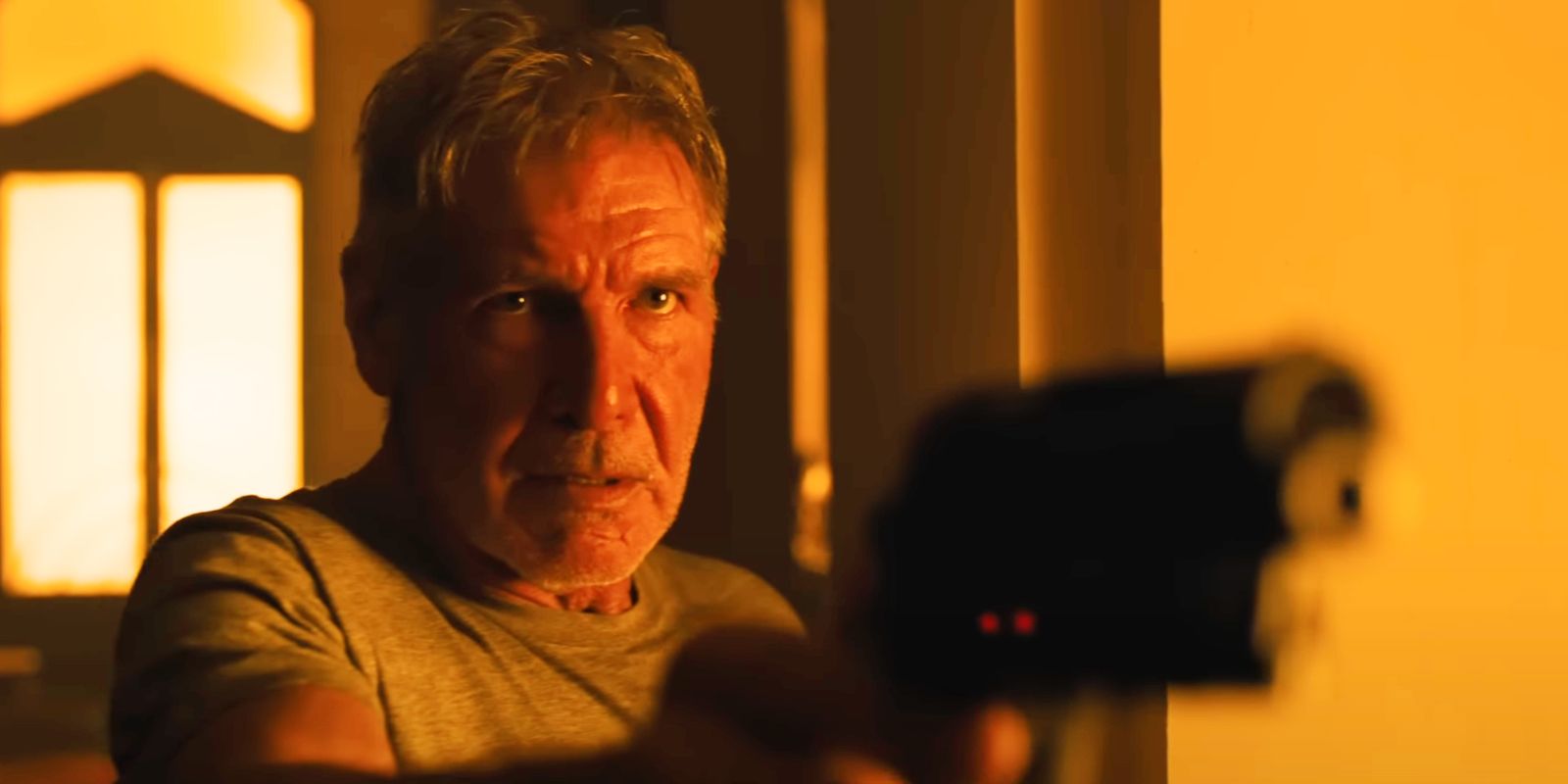 Harrison Ford como Deckard em Blade Runner 2049 segurando uma arma