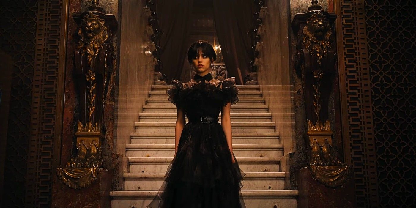 Wednesday (Jenna Ortega) descends the staircase at Nevermore in a black dress in Wednesday.