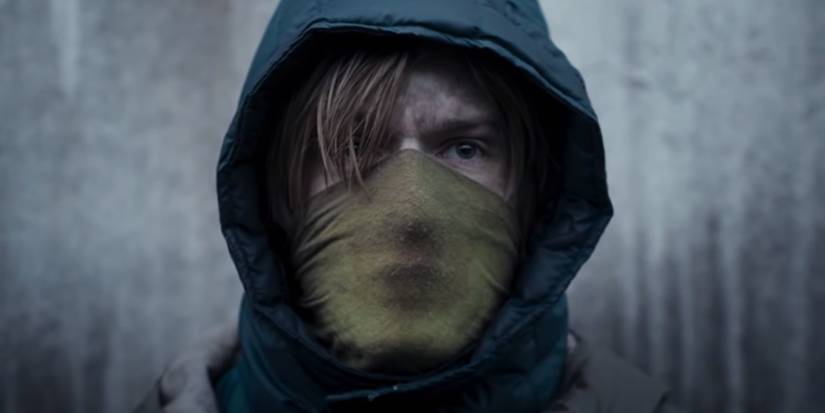 Louis Hofmann like Jonas Kahnwald with a facial mask and with his hood in darkness.