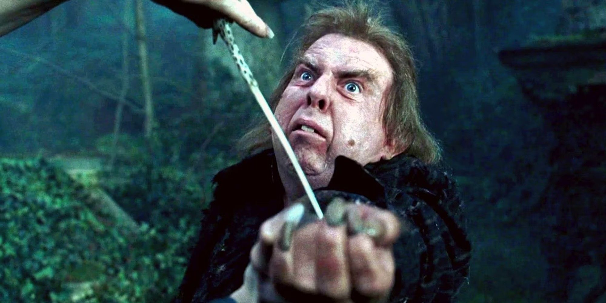Peter Pettigrew em Harry Potter parece assustado com uma varinha apontada para o pulso