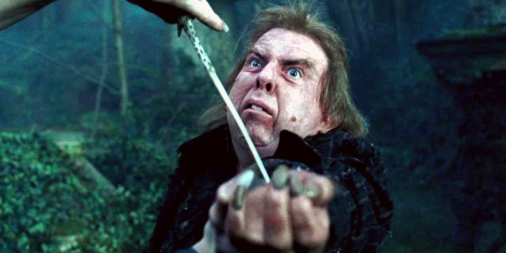Peter Pettigrew in Harry Potter looking scared with a wand pointed at his wrist.