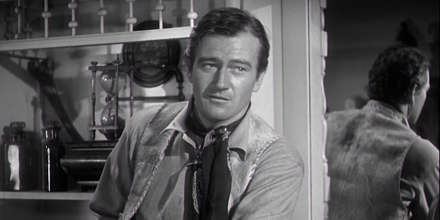 John Wayne appoggiato a un muro in Dark Command