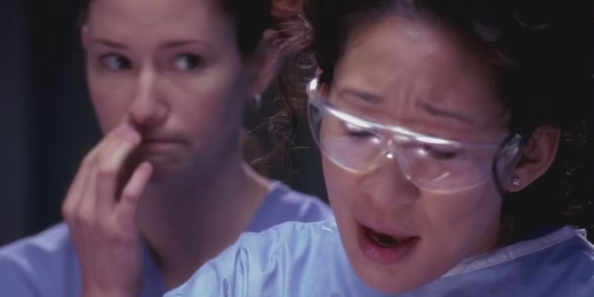 Lexie (Chyler Leigh) standing behind Cristina (Sandra Oh) while they work in Greys Anatomy