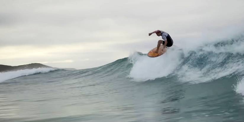 A still of someone surfing in Surviving Summer season 2 on Netflix.