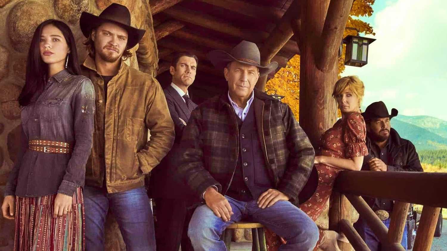 The cast of Yellowstone on a cabin porch