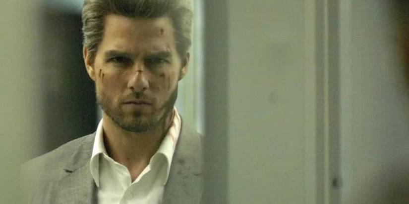 A scratched up Tom Cruise as Vincent looking intensely in Collateral