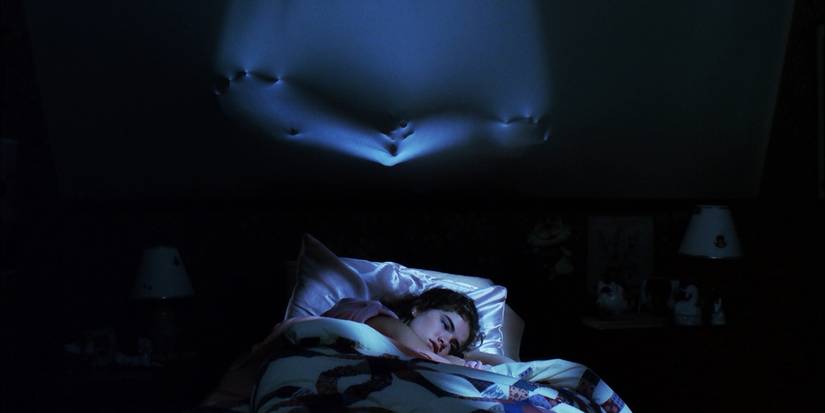 Nancy (Heather Langenkamp) laying in bed while Freddy Krueger (Robert Englund) comes through the wall in A Nightmare on Elm Street (1984)