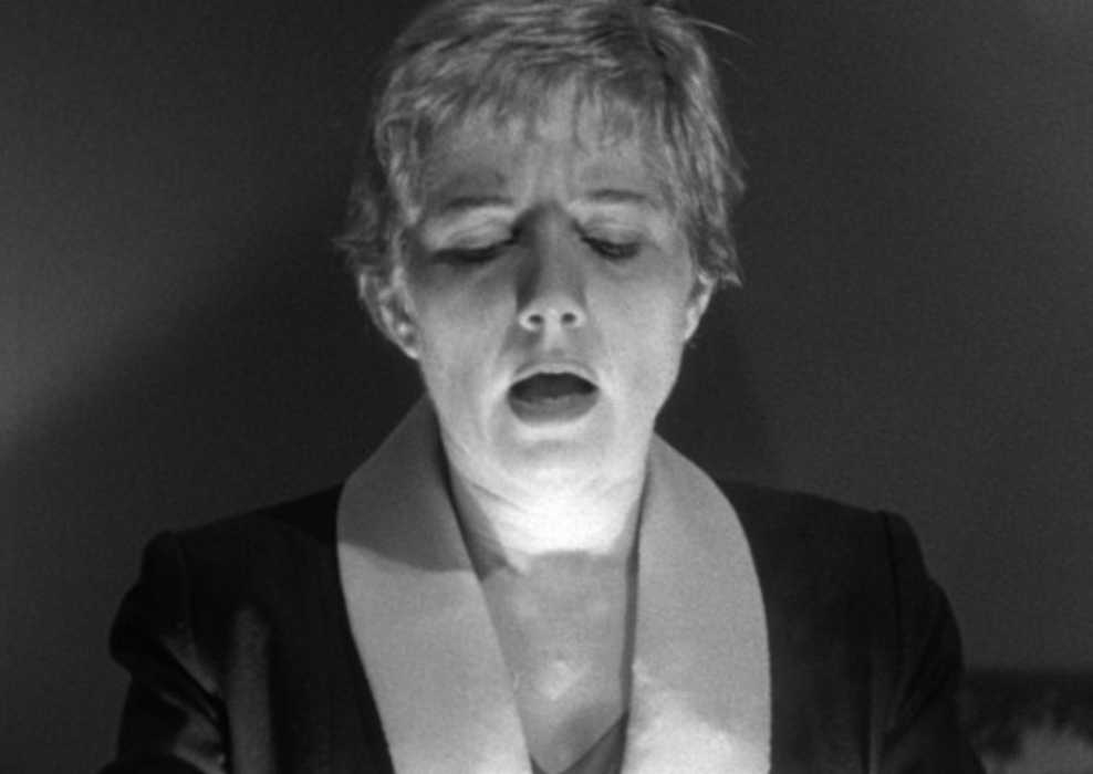 A woman looks shocked as she opens the glowing box in Kiss Me Deadly