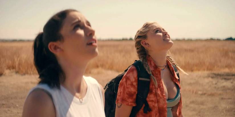 Grace Caroline Currey and Virginia Gardner looking up at the tower nervously in Fall