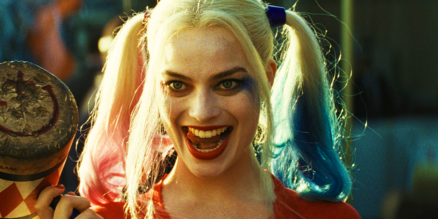 Margot Robbie with a big smile holding her mallet as Harley Quinn in The Suicide Squad