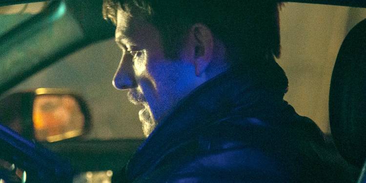 Joel Kinnaman in a car with a gun in Silent Night