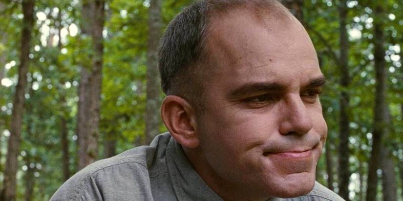 Karl (Billy Bob Thornton) looks on while sitting in the woods in Sling Blade
