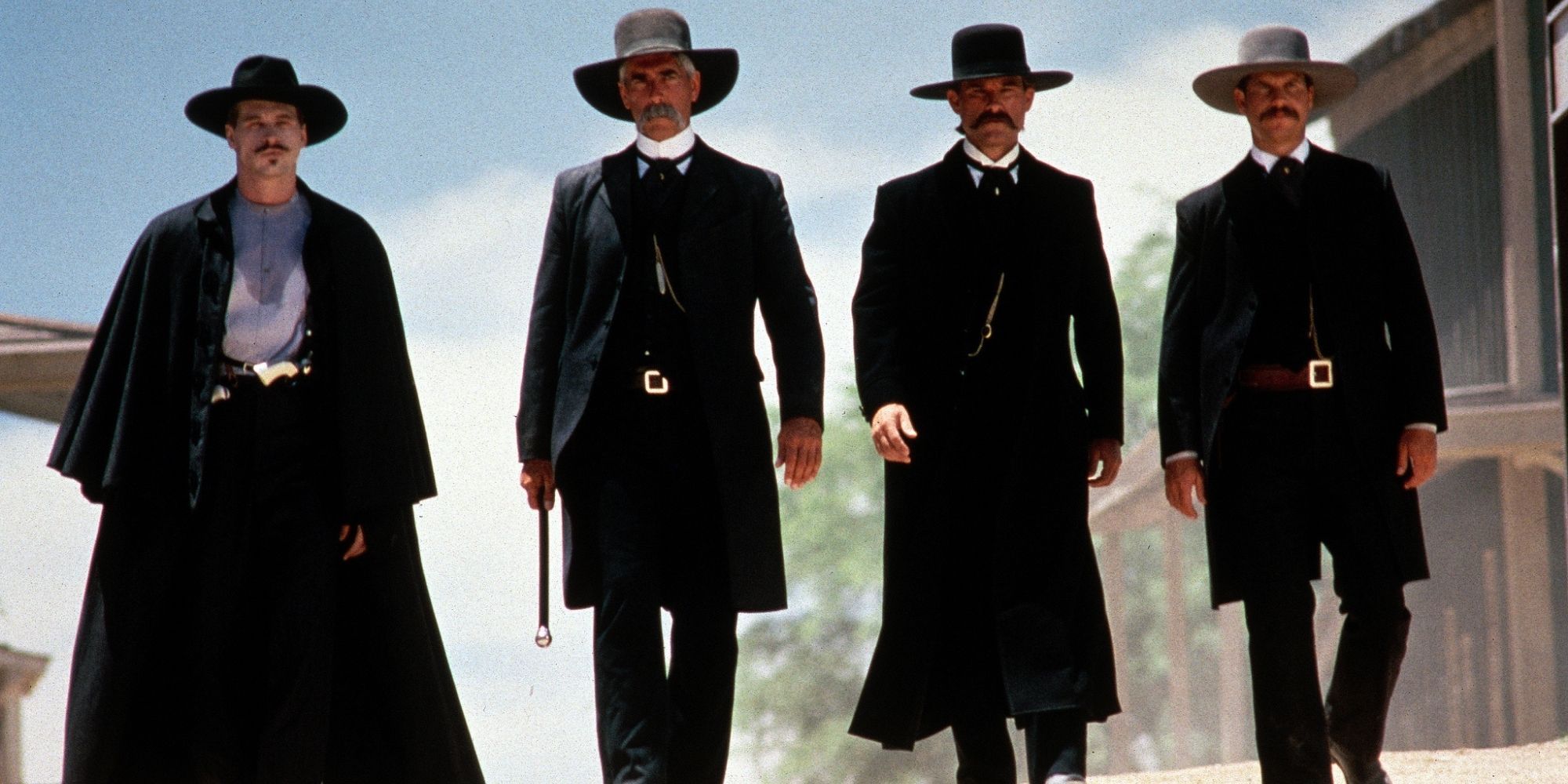 Val Kilmer as Doc Holliday, Sam Elliott as Virgil Earp, Kurt Russell as Wyatt Earp, and Bill Paxton as Morgan Earp as they walk through town in Tombstone.