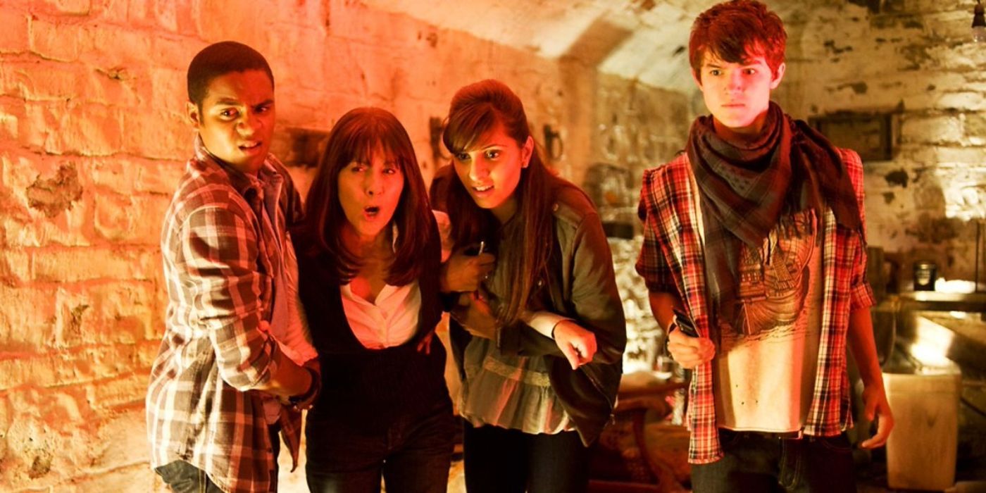 Sarah Jane holding Clyde and Rani close to her while Luke stands to the side in The Sarah Jane Adventures