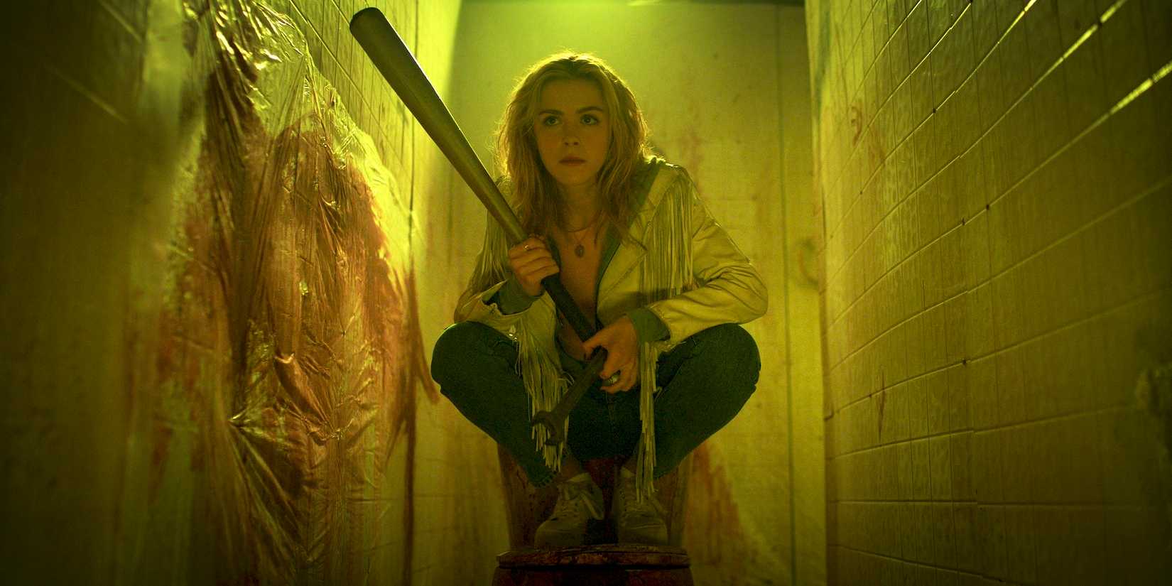 Kiernan Shipka crouches hoding bat in totally killer 