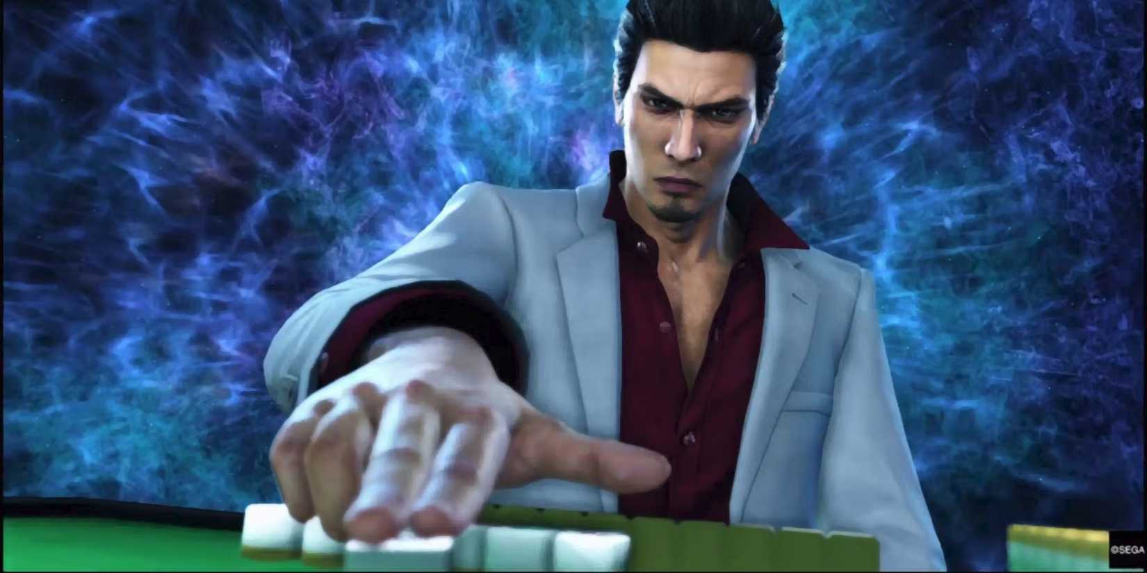 Kiryu, surrounded by blue waves of energy, sets down a mahjong tile in a screenshot frm Yakuza Kiwami 2.