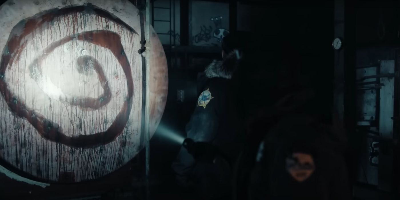 a police offer aims a flashlight beam at a spiral symbol on a white surface in True Detective: Night Country