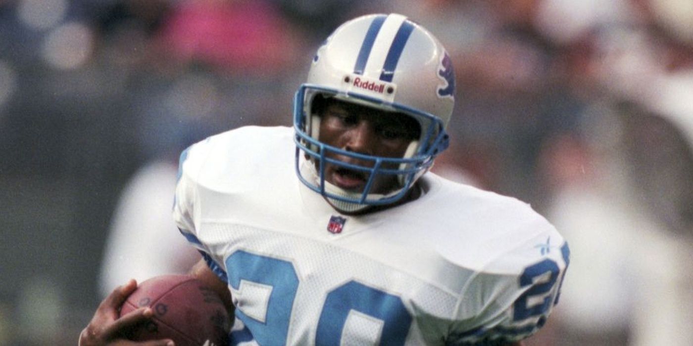 Barry Sanders of the Detroit Lions clutching a football in white uniform