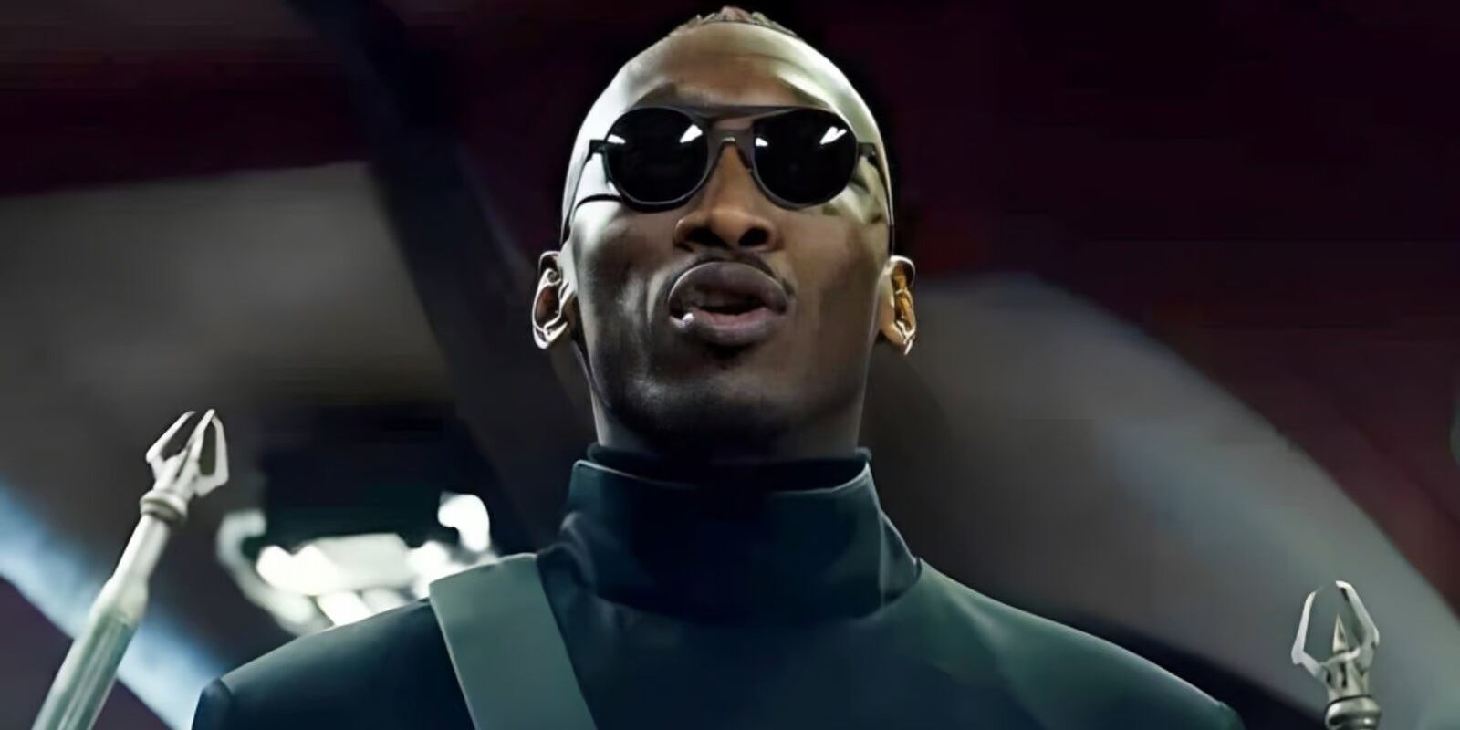 Mahershala Ali in Alita Battle Angel talking and wearing sunglasses