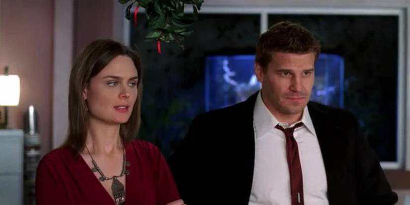 Brennan and Booth standing under mistletoe in Bones