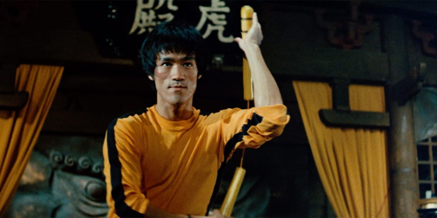 Billy Lo con su icónico chándal amarillo mientras sostiene un par de nunchakus amarillos en Game of Death