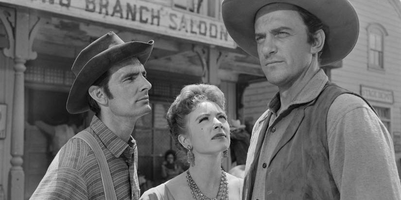 Dennis Weaver, Amanda Blake, and James Arness as Chester Goode, Kitty Russel, and Matt Dillon standing together in Gunsmoke